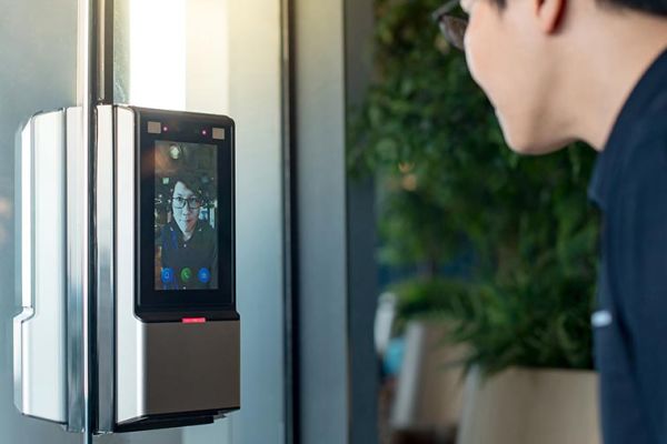 Man using a video intercom system at a secure building entrance