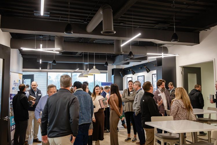 Group of people networking in a modern office space with pendant lighting