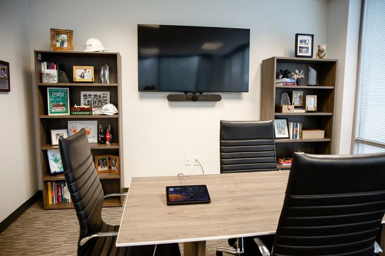 Small meeting room with TV, bookshelves, and a tablet on the table