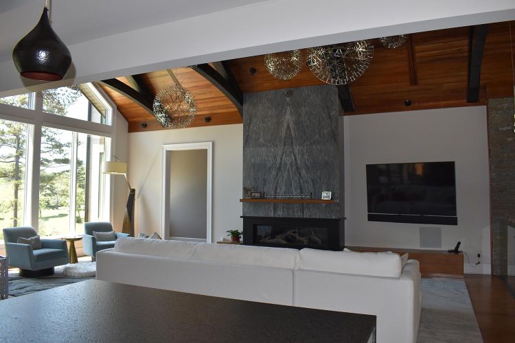 Marble fireplace and TV wall in modern living room with white sofa and vaulted ceiling