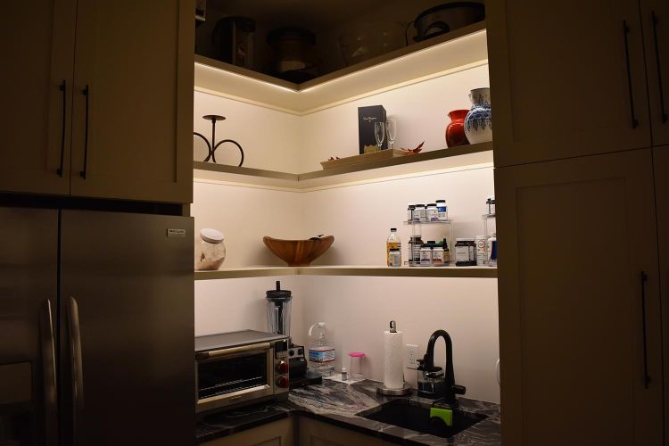 Pantry with floating shelves, under-cabinet lighting, and small appliances
