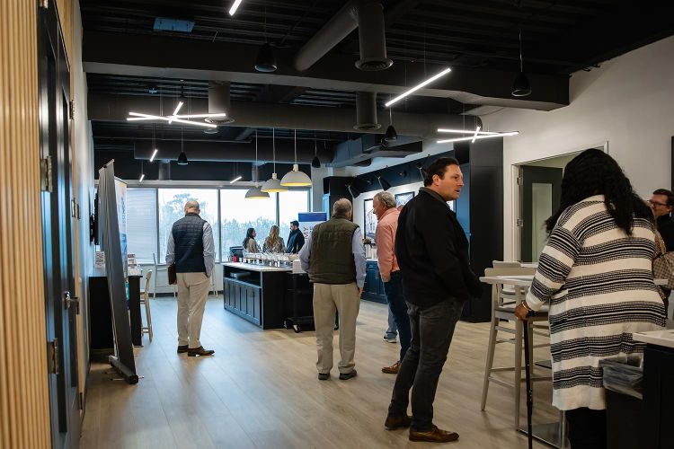Group of people gathered in a modern open office kitchen area