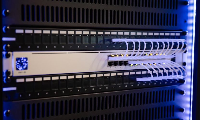 Close-up of a network switch with neatly organized white ethernet cables